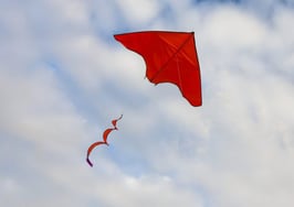 A red kite flying in the sky