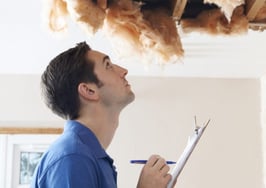 A homeowner and an inspector looking at a collapsed ceiling