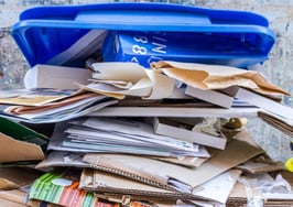 A stack of papers in a recycling bin