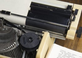 A typewriter with a sheet of paper