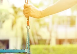A woman sitting alone on a swingset