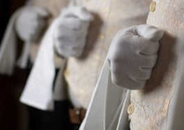 A row of high-end waiters holding napkins