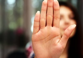 A woman holding up a hand in objection
