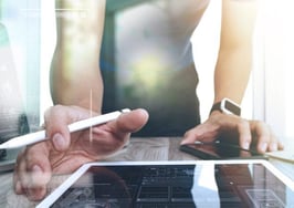 A man typing on a tablet computer