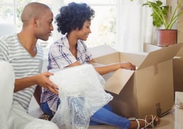 A black couple unpacking boxes in their new home