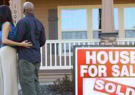 Homeowner couple in front of sold house