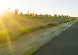 Car driving on road trip sunrise