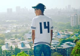 Man in baseball jersey uniform overlooking Mumbai