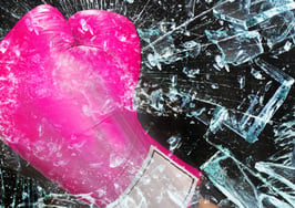 Pink boxing glove smashing glass
