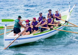People rowing a boat out at sea