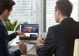 two men looking at a laptop