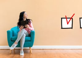 Checklist with young woman holding a tablet computer in a chair