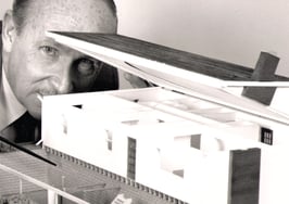 man looking at model of house