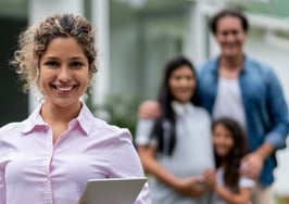 realtor looking at camera in front of clients