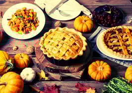 A picture of a Thanksgiving table replete with pies to represent fall-themed stop-by ideas.
