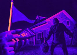 A dark manly figure outside of a house with a red flag and a hand using an app to symbolize real estate safety tools.