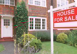 House with a "for sale" sign in the front yard