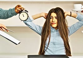 An image of a woman who's being overwhelmed with time, contracts and other distractions to symbolize real estate self-sabotage.