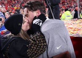 A picture of Taylor Swift kissing Travis Kelce with onlooking fans watching to represent Taylor Swift-level client loyalty in real estate.