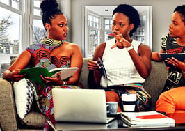 3 African-American single women homebuyers talking with each other on the couch.