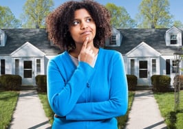 A woman in front of a home asking herself the rent vs. buy question.