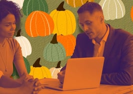 A couple sitting around a table with their real estate agent with pumpkins in the background to signify low-inventory market strategies for fall.