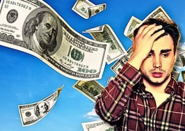 An image of a man with his hand on his forehead looking distressed as money flies away to represent how to avoid costly seller leads.