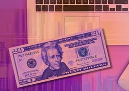 A $20 bill on top of a laptop to exemplify how to fulfill your marketing needs with AI in 2025.