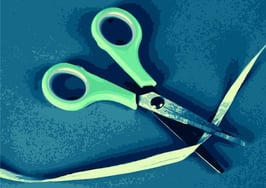 Scissors cutting a ribbon, symbolizing NAR's elimination of eight governance committees.