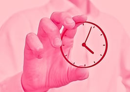 An image of a hand holding a clock to represent a full-time real estate agent.