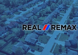 A Real REMAX group logo over an image of a neighborhood to signify the Real REMAX merger.