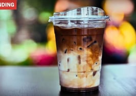 A clear plastic cup of iced coffee with a straw representing the ice coffee debate.