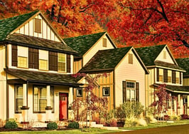 An image of homes in front of fall foliage to represent real estate fall marketing calendar.