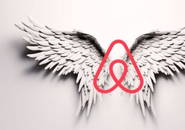 An image of angel wings with the Airbnb logo as the body to represent whether the Airbnb $250 million housing fund will be the angel or devil of housing supply.