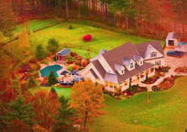 A picture of a home surrounded by fall foliage to represent 2026 luxury homebuyer trends this fall.