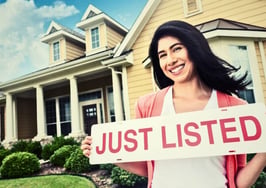 Agent holding just listed sign showing how US home listings are up