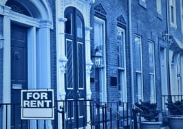 For-rent sign outside a single-family home, illustrating the cost gap in renting vs. buying