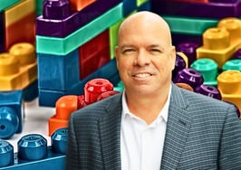 An image of Jimmy Burgess in front of legos to represent how to increase real estate income.