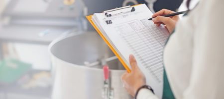 A woman marking items off a test-kitchen clipboard