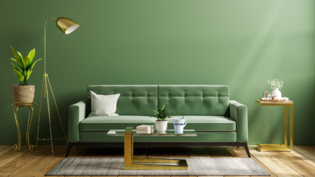 A green couch in front of a green wall in a beautifully staged room to illustrate how to overcome seller home staging objections.