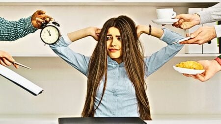 An image of a woman who's being overwhelmed with time, contracts and other distractions to symbolize real estate self-sabotage.