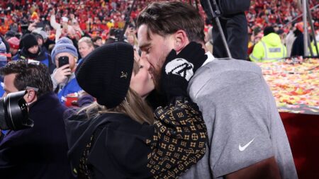 A picture of Taylor Swift kissing Travis Kelce with onlooking fans watching to represent Taylor Swift-level client loyalty in real estate.