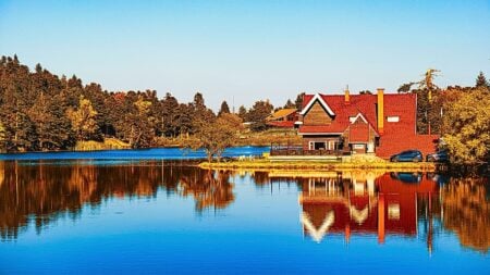 A beautiful home on a lake during autumn to illustrate fall listing refresh strategies.