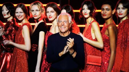 A photo of Giorgio Armani among fashion models to represent brokerage leadership lessons from Giorgio Armani.