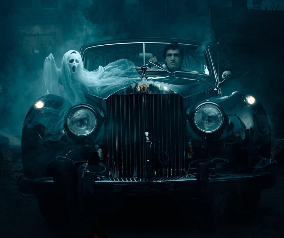 A ghost and a ghoul in a spooky car to represent real estate monsters.