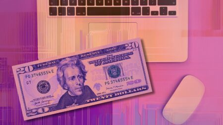 A $20 bill on top of a laptop to exemplify how to fulfill your marketing needs with AI in 2025.