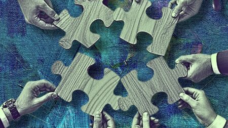 Four pairs of hands, each providing a piece of a puzzle to reflect how real estate teams work.