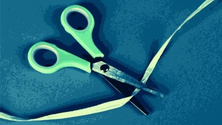 Scissors cutting a ribbon, symbolizing NAR's elimination of eight governance committees.