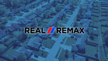 A Real REMAX group logo over an image of a neighborhood to signify the Real REMAX merger.
