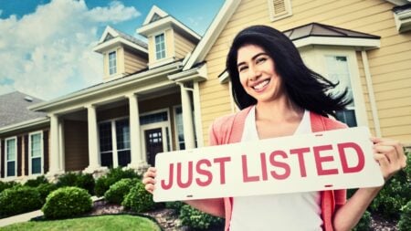 Agent holding just listed sign showing how US home listings are up